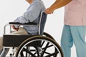 42-16902295 - Nurse pushing man in wheelchair